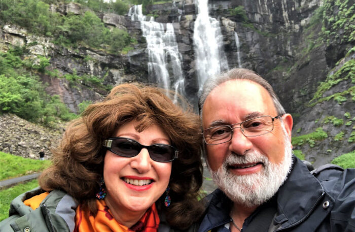 Happy couple having selfie with the falls on the mountain